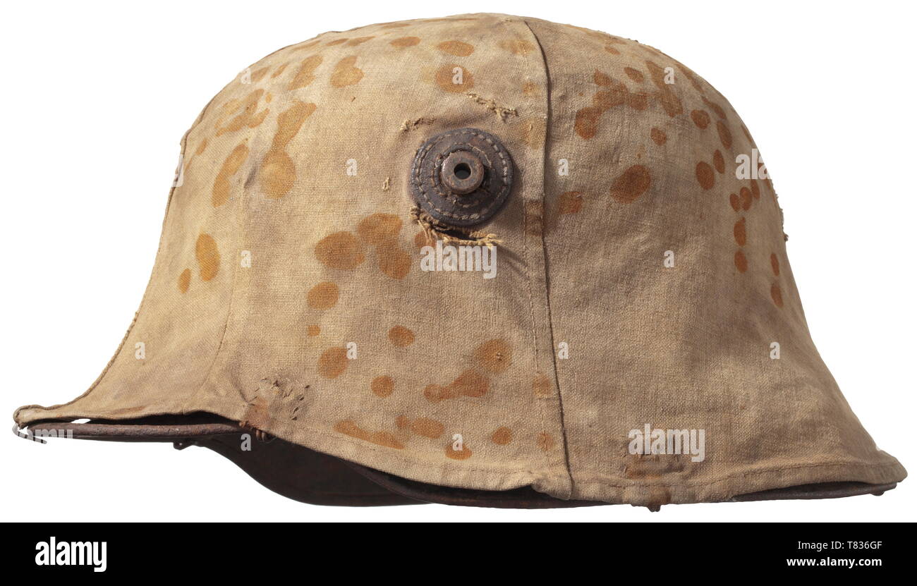 Un casco in acciaio M 16 con camouflage Campo di copertura-grigio acciaio verniciato il cranio con un contemporaneo coperchio di mimetizzazione di biancheria pesante sabbia-materiale colorato con ruggine-brown flecks, con sei morsetti magnetici per il fissaggio al casco e rinforzi in pelle per i prigionieri di ventilazione, il cranio interno con la timbratura ha colpito "ET 64', il rivestimento con un cuoio anello interno e i resti dei tre tamponi in pelle. I segni dell'età e dell'uso. Una molto rara e casco di copertura tipica frontline fare. storica, storica del xx secolo, 1910s, la Prima Guerra Mondiale / WWI,, Additional-Rights-Clearance-Info-Not-Available Foto Stock