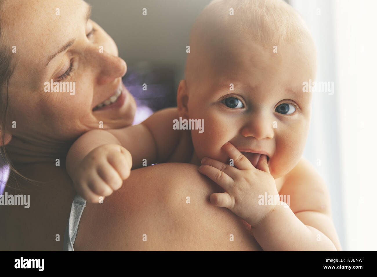 Felice giovane madre con bambino sopra la spalla Foto Stock