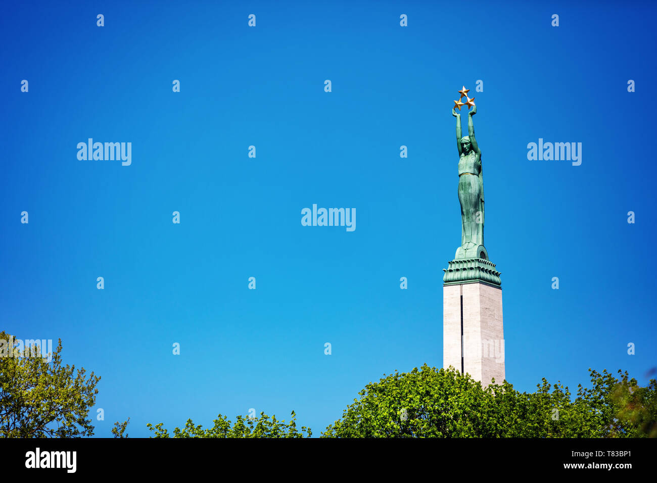 I punti di riferimento della Lettonia - il monumento alla libertà di Riga contro il cielo blu Foto Stock