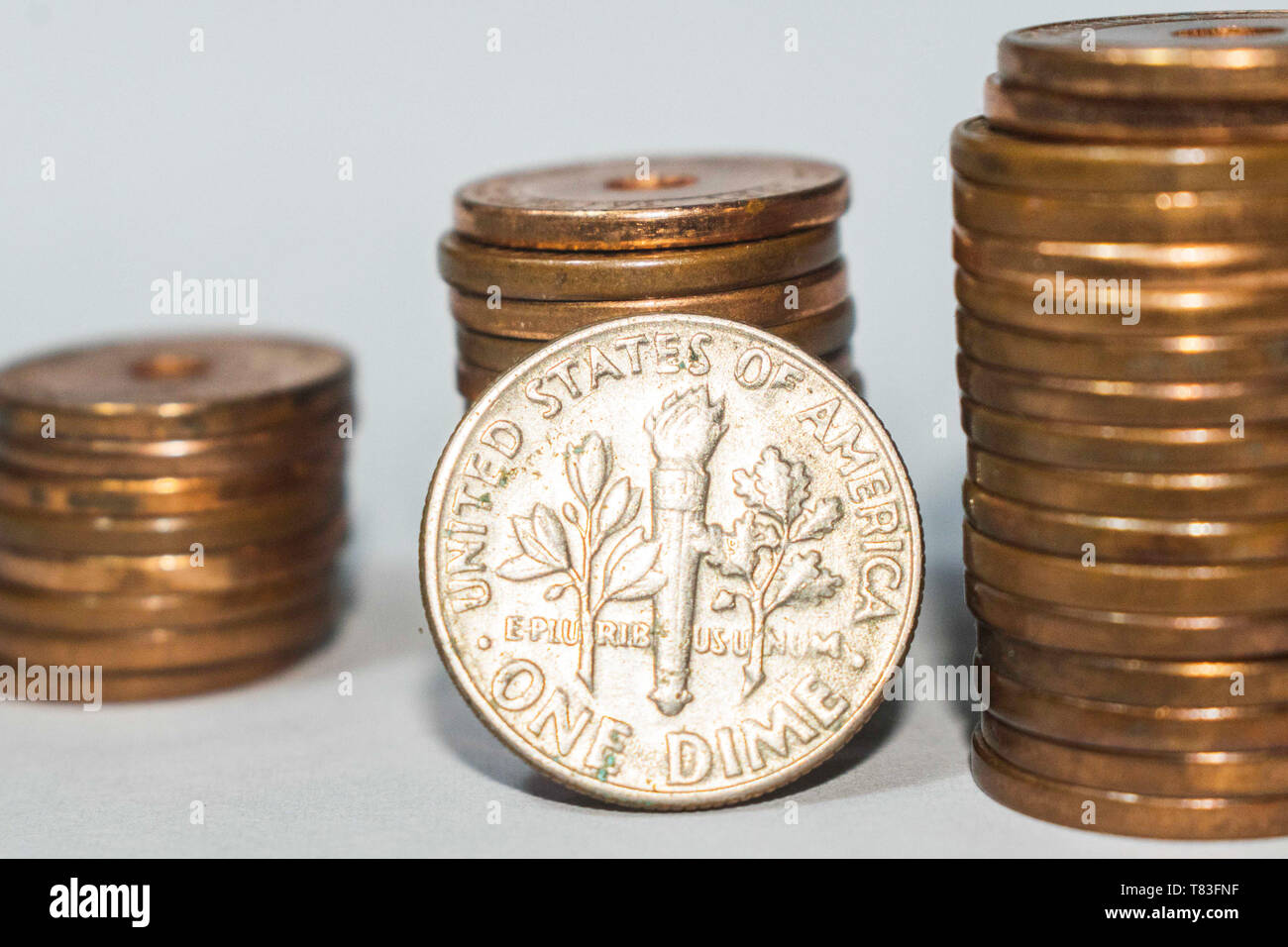 American 10 centesimi, noi una monetina con monete impilate sullo sfondo Foto Stock