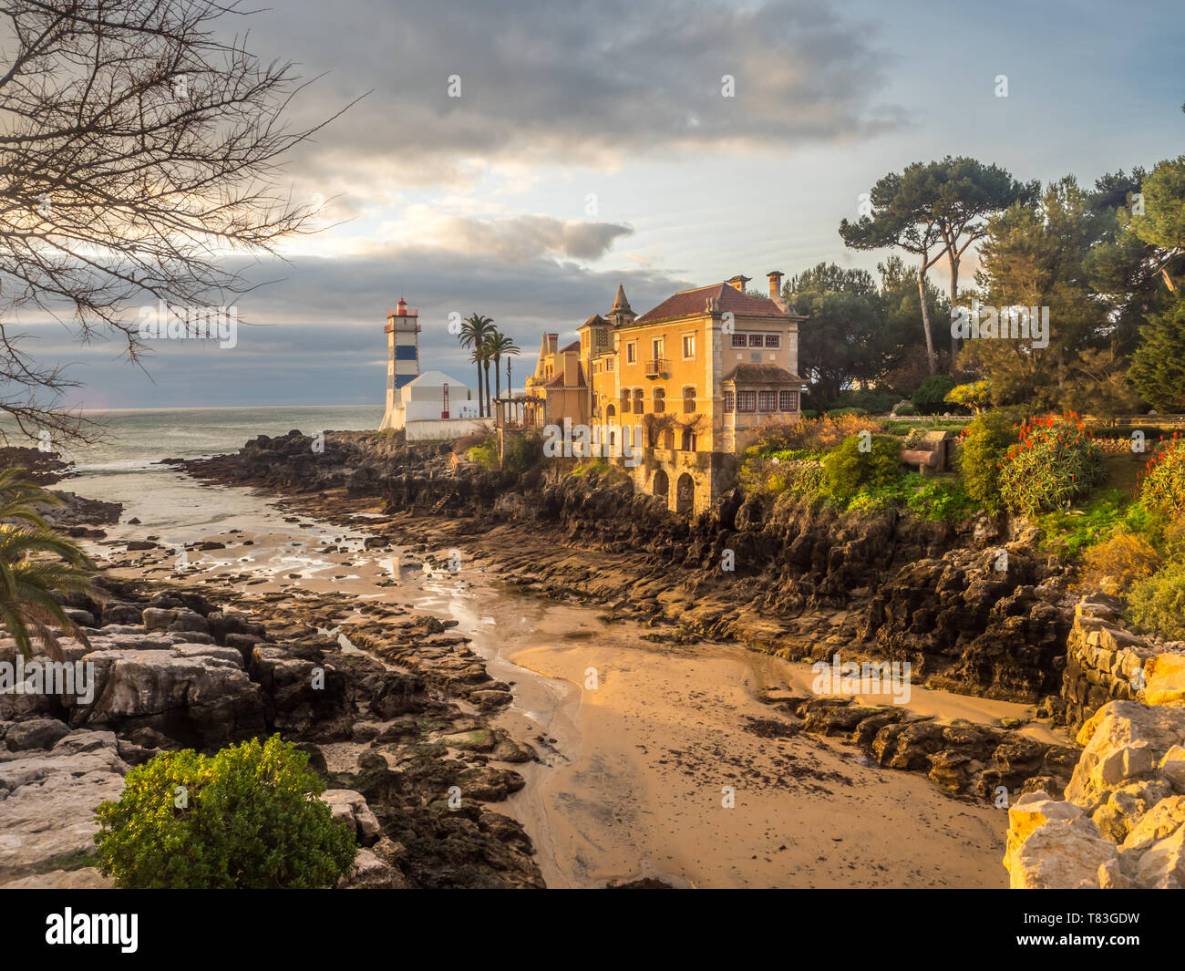 Sunrise vista di Santa Marta faro e il museo municipale di Cascais durante il deflusso dell'oceano, in Portogallo. Foto Stock