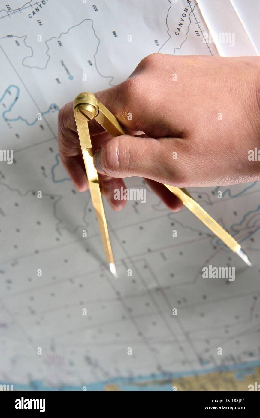 Francia, Var, Tolone, la base navale (Arsenale), il Charles de Gaulle nuclear powered portaerei sulla metà del rinnovamento di vita, ponte di navigazione officer a studiare una mappa con la sua bussola Foto Stock