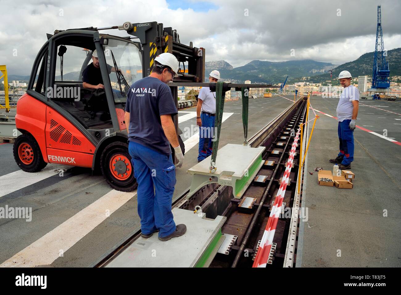 Francia, Var, Tolone, la base navale (Arsenale), il Charles de Gaulle nuclear powered portaerei sulla metà del rinnovamento di vita, il ponte di volo, i lavoratori della compagnia navale di ritirare le schede di pit della catapulta anteriore Foto Stock