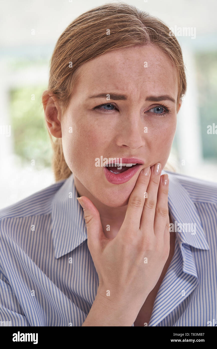 Giovane donna soffre di mal di denti tocchino la ganascia Foto Stock