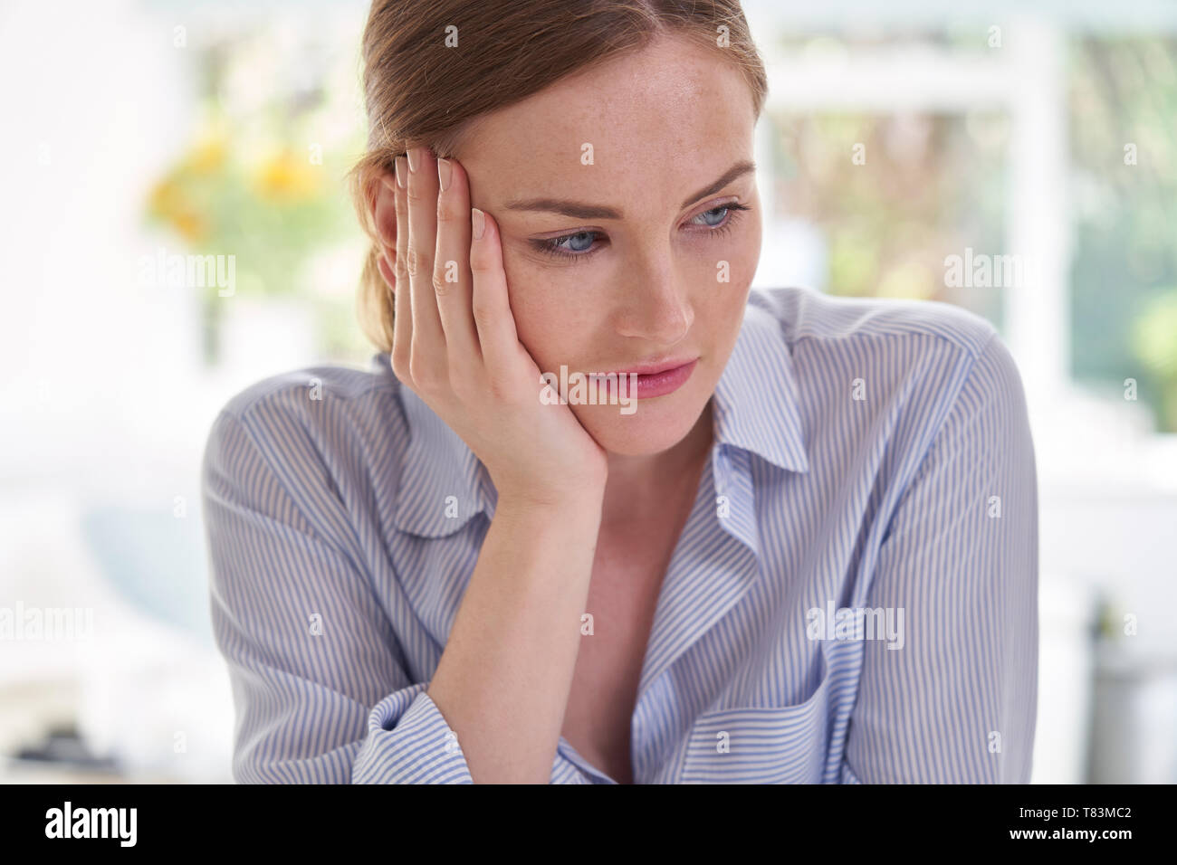 Triste giovane donna che soffre di depressione con testa in mani Foto Stock