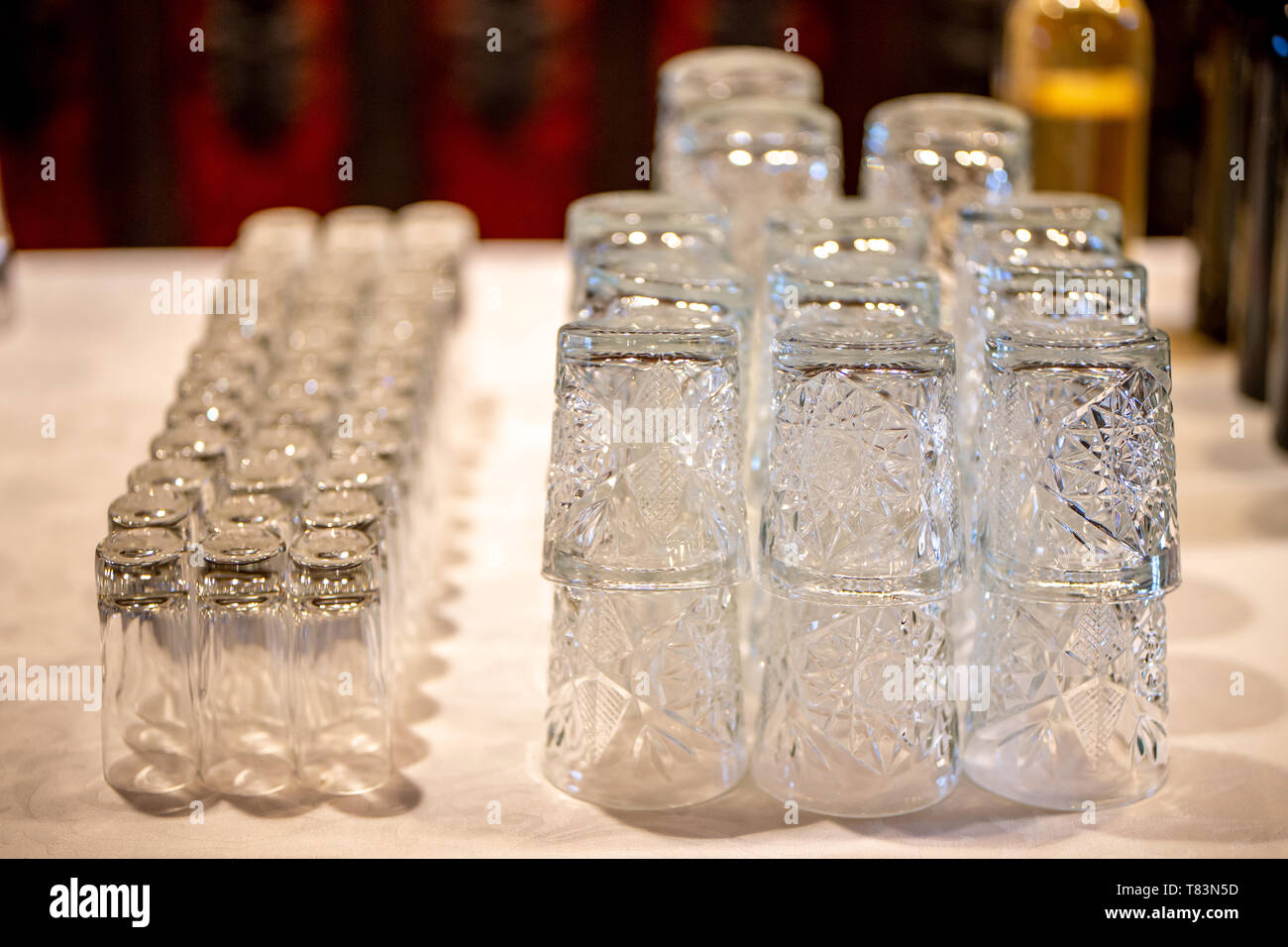 Bicchieri vuoti sul tavolo bianco nel ristorante. Sacco di bicchieri di cristallo disposti sul tavolo per il ricevimento di nozze. Foto Stock