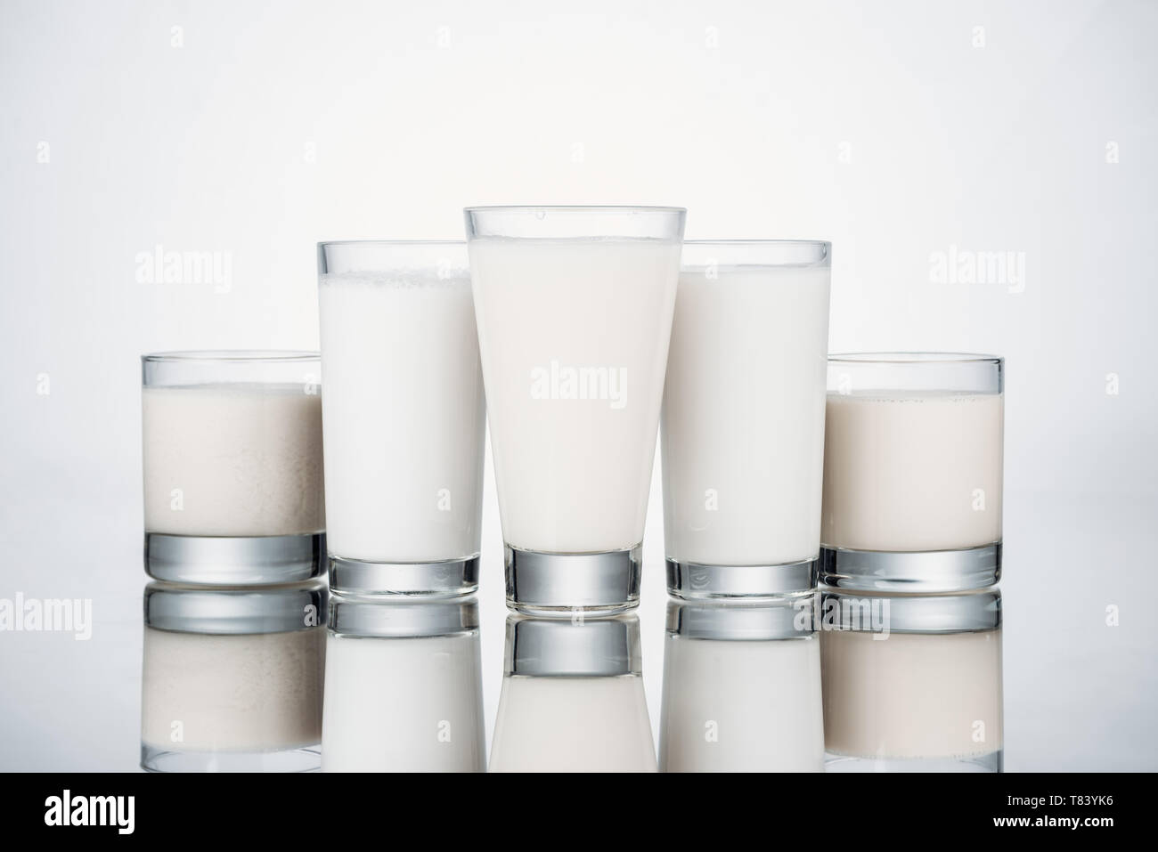 Occhiali con organici latte alternativi su uno sfondo grigio con la riflessione Foto Stock