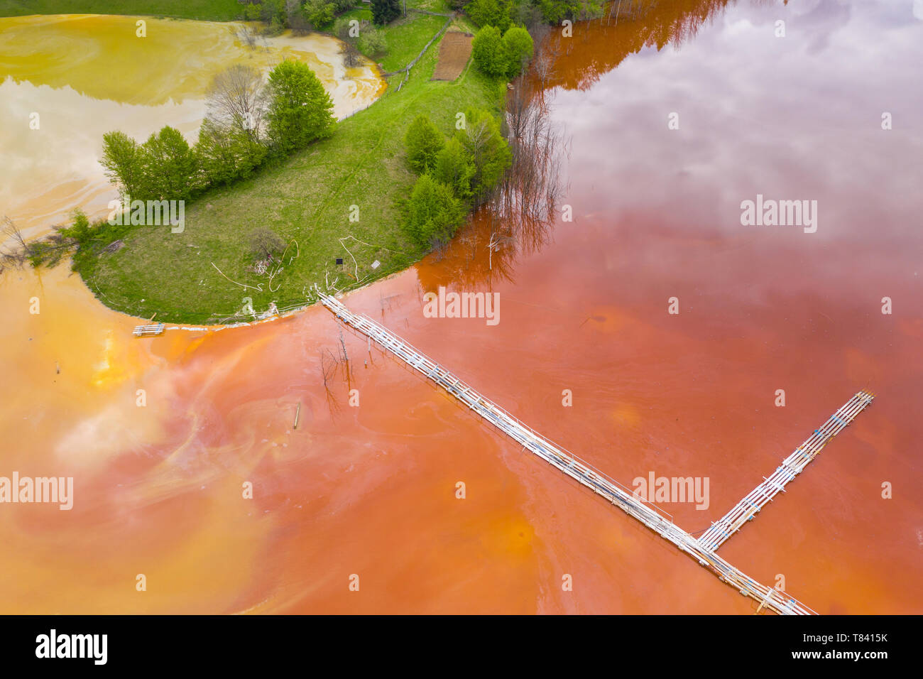 Vista aerea della miniera acido il drenaggio e colorati di rosso miniera di rame acqua di inondazione del ambiente naturale da fuco. Geamana Rosia Montana, Romania Foto Stock