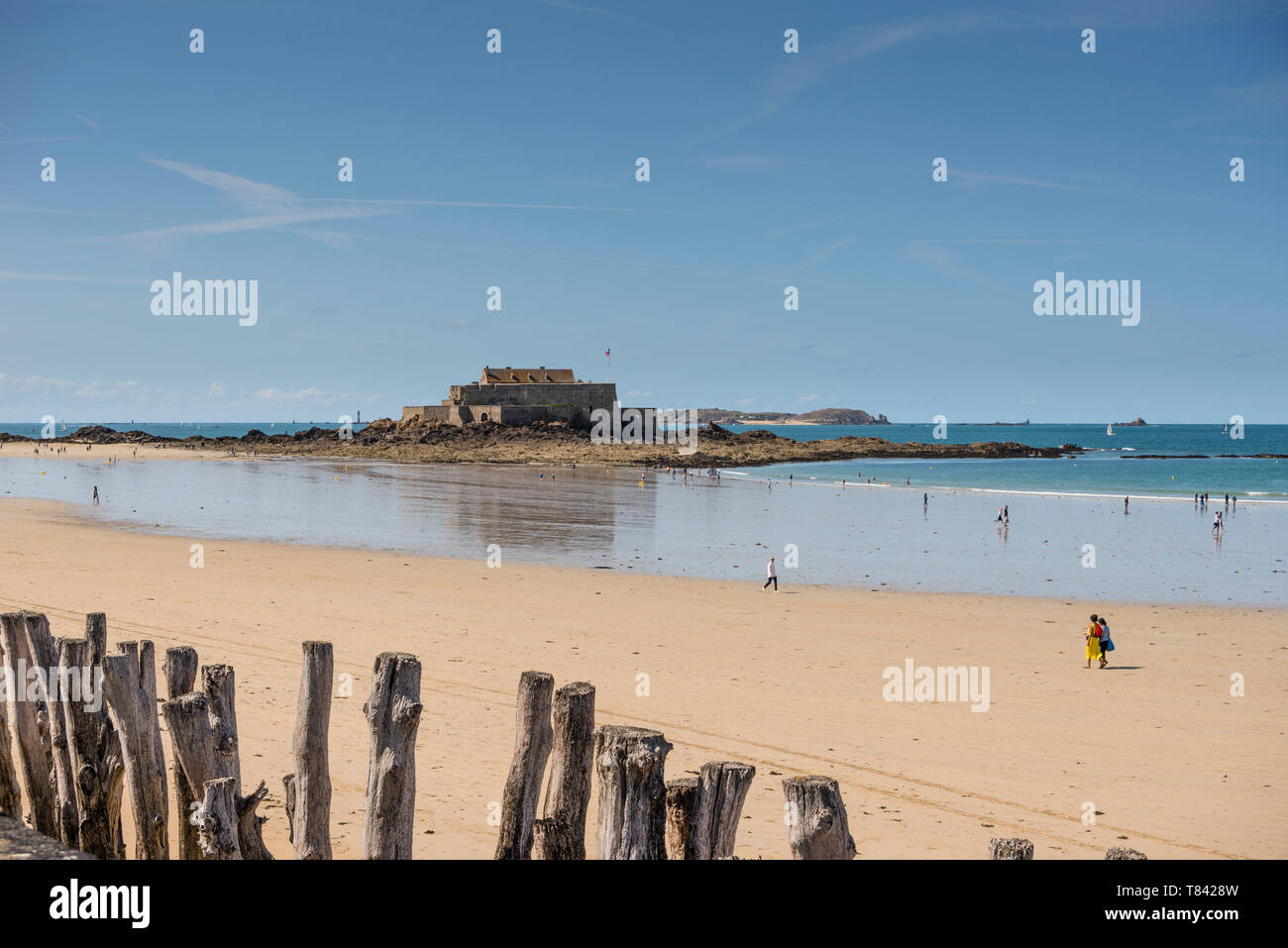 La gente sulla spiaggia sabbiosa e la vista del mare con il Fort National in background, Bretagna Francia Foto Stock