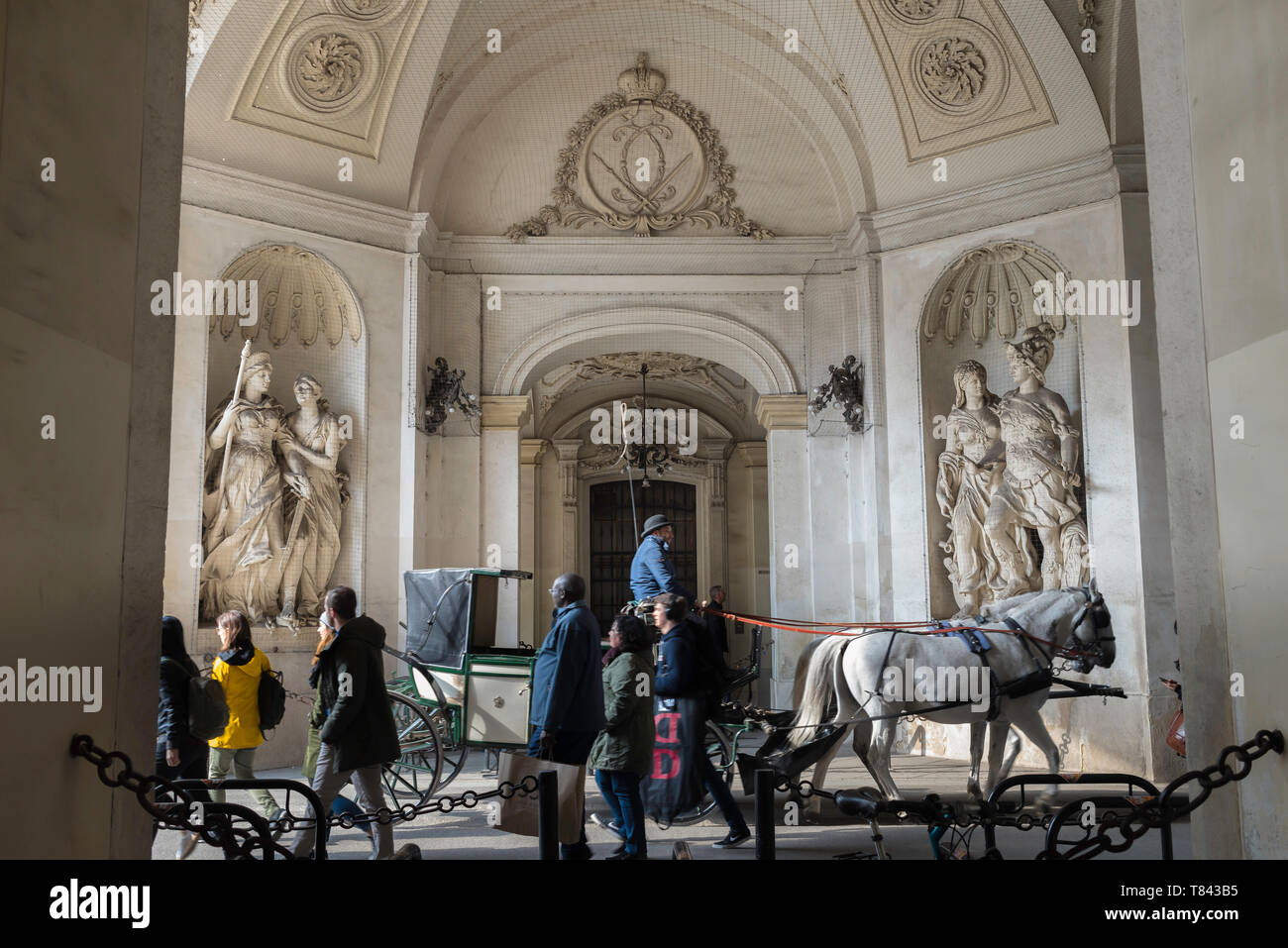 Porta di San Michele, vista su una carrozza trainata da cavalli che passa attraverso la porta di San Michele, ingresso principale del complesso del Palazzo di Hofburg a Vienna, Austria. Foto Stock