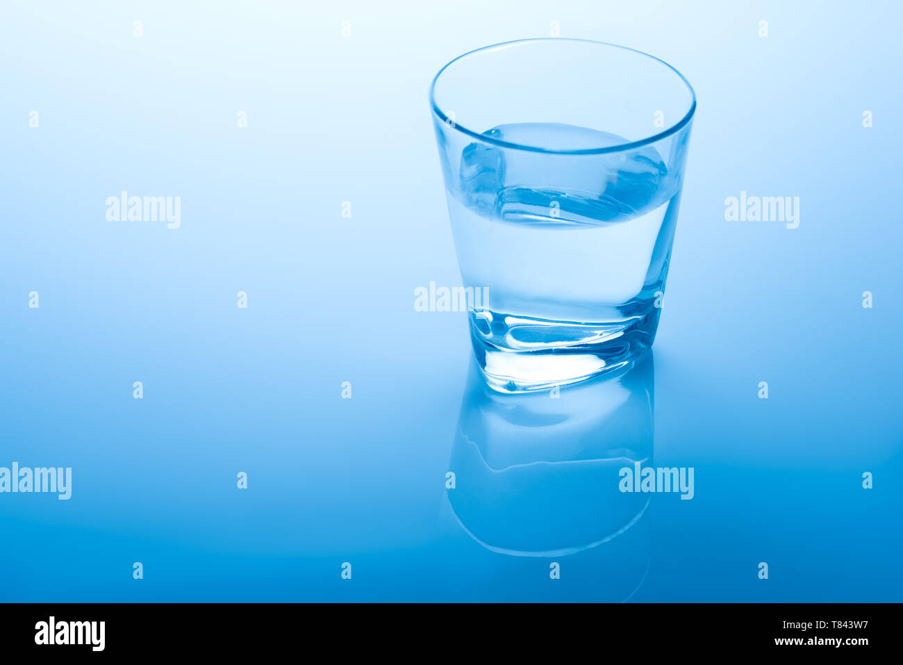 Bicchiere di acqua su sfondo blu Foto Stock
