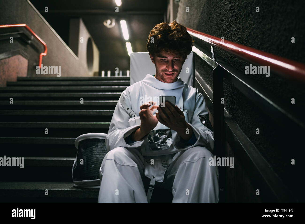 Astronauta utilizza lo smartphone sulla scaletta Foto Stock