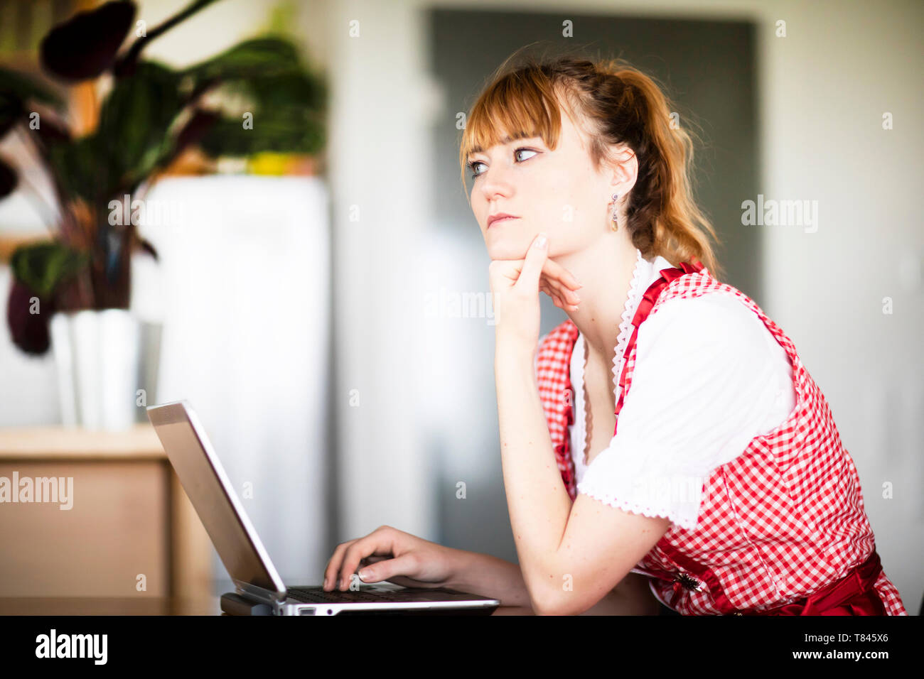 La donna nel pensiero profondo, utilizzando laptop in home office Foto Stock