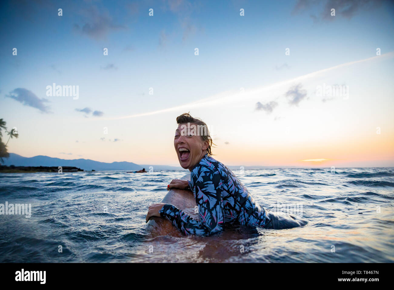 Surfer scorrevolezza in mare al tramonto, Pagudpud, Ilocos Norte, Filippine Foto Stock