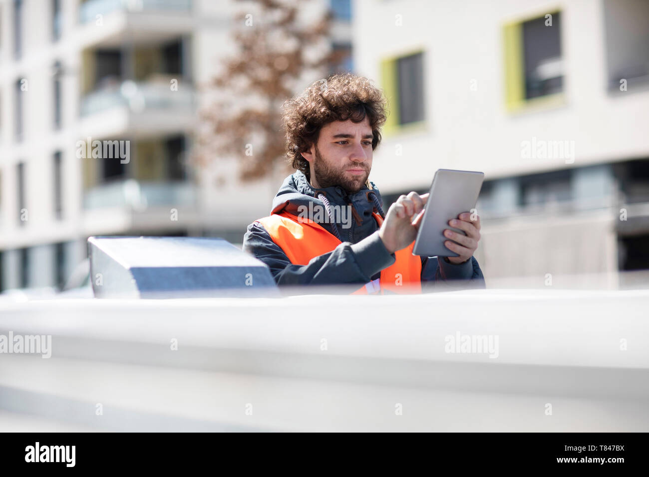 Uomo con tavoletta digitale su strada Foto Stock