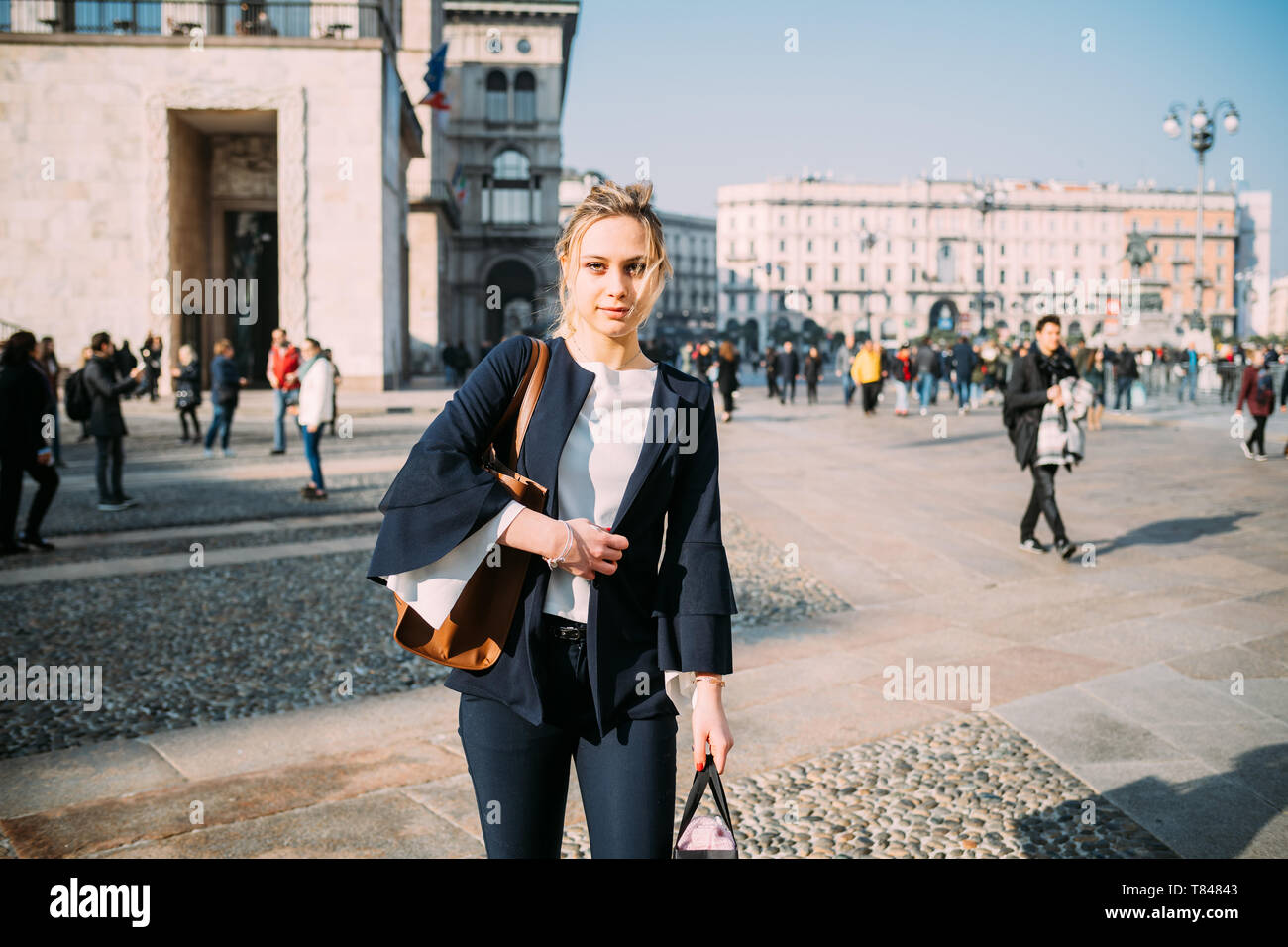Giovane turista femminile con le borse della spesa in city square, Milano, Italia Foto Stock