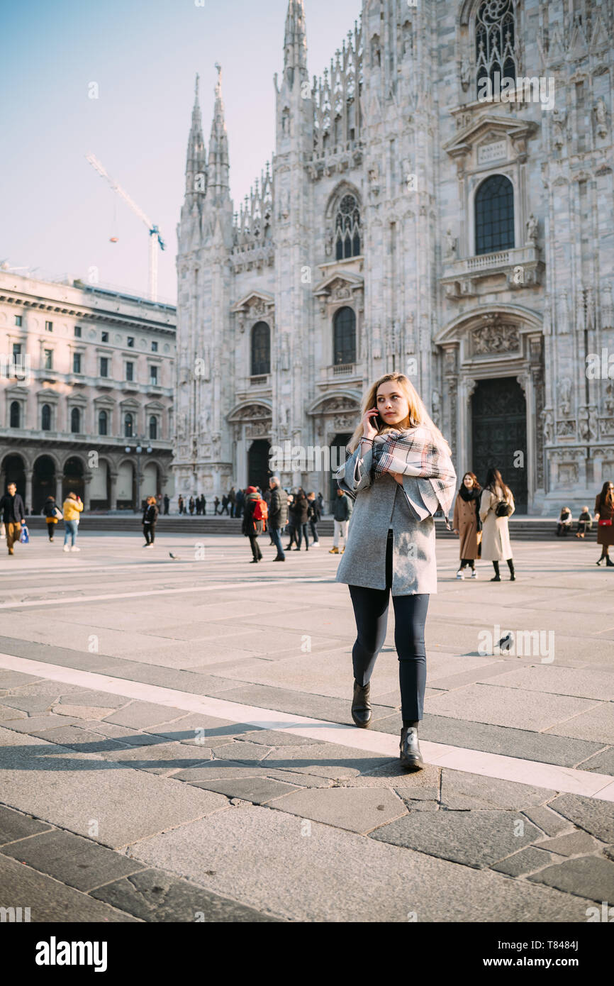 Giovane turista femminile rendendo chiamata allo smartphone dal Duomo di Milano, Milano, Italia Foto Stock