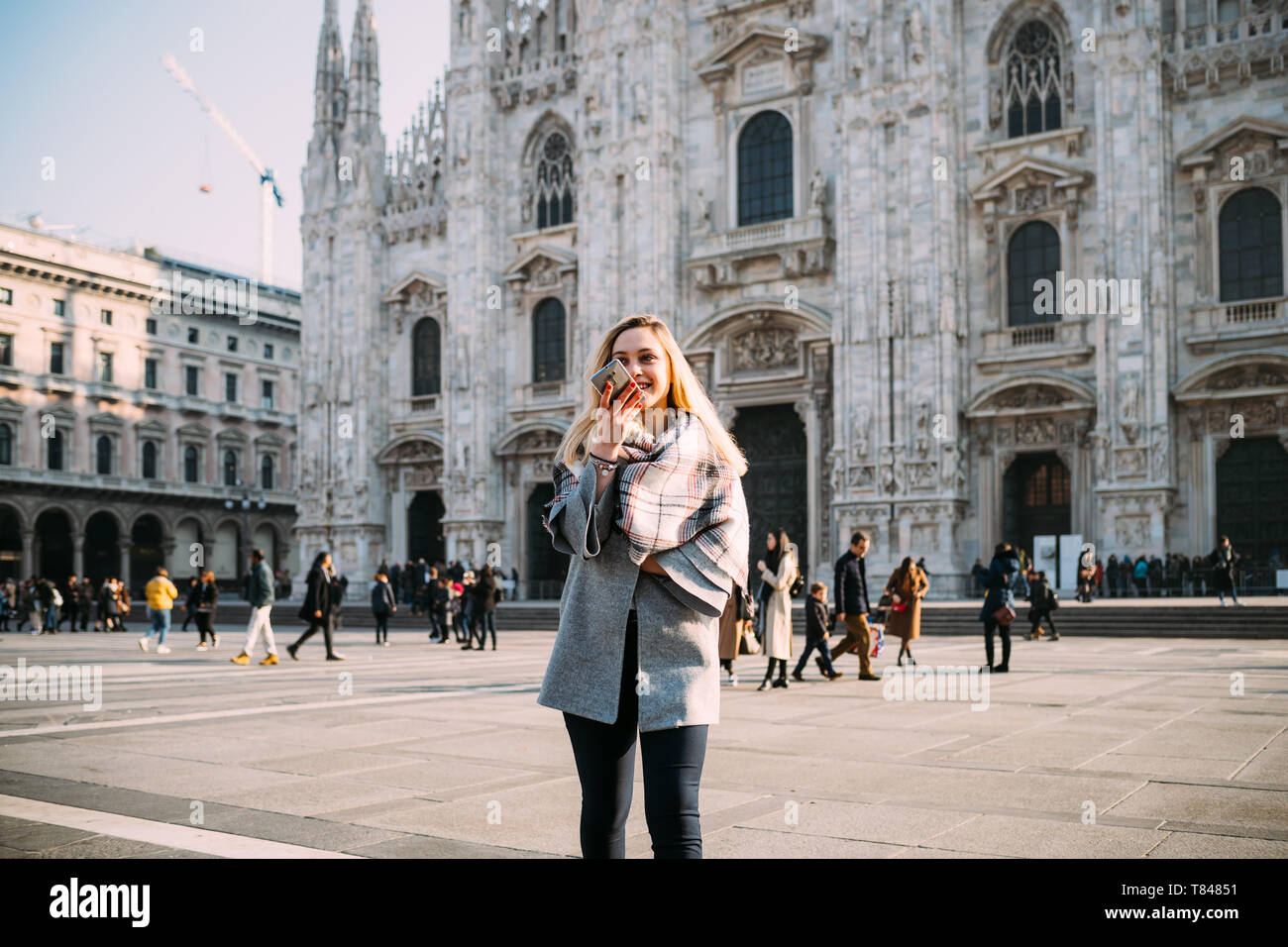 Giovane turista femminile parlando a smartphone dal Duomo di Milano, Milano, Italia Foto Stock