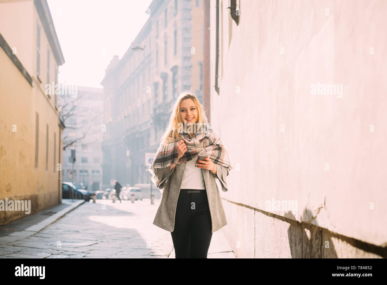 Giovane turista femminile avvolto in scialle, ritratto, Milano, Italia Foto Stock