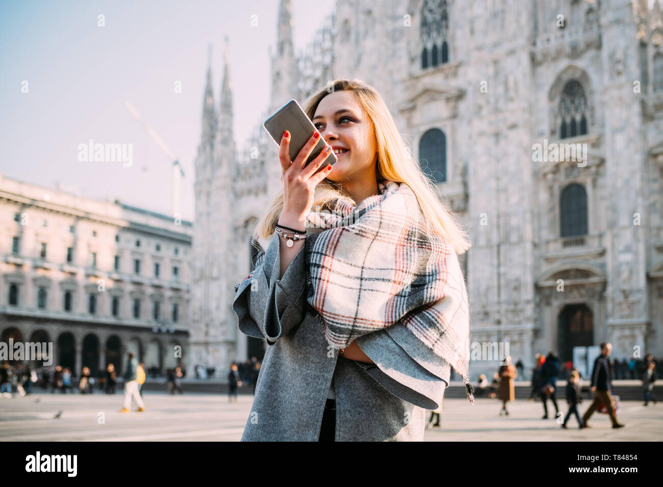 Giovane turista femminile parlando a smartphone dal Duomo di Milano, Milano, Italia Foto Stock