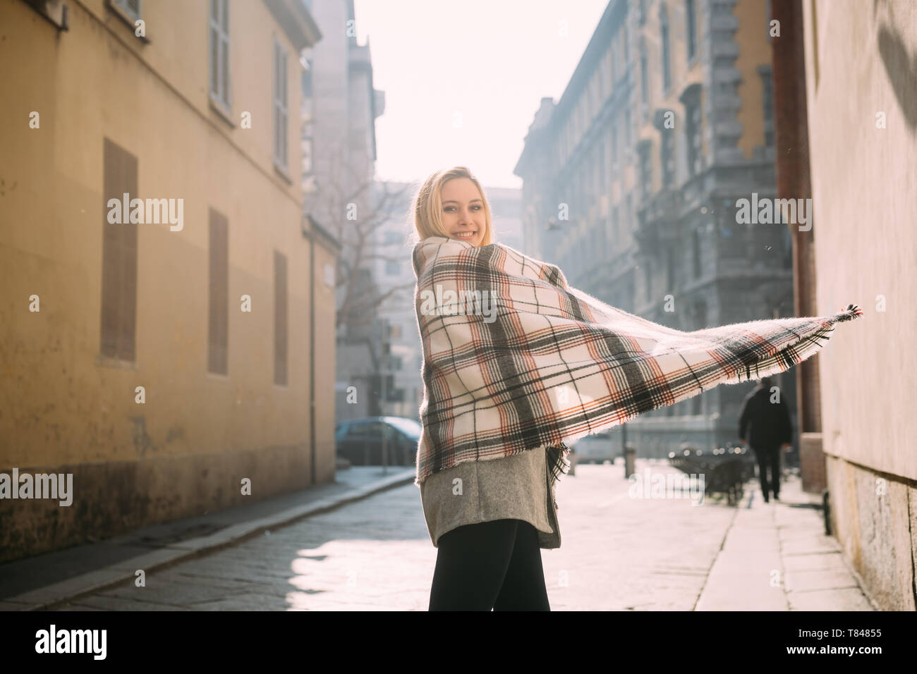 Giovane turista femminile avvolto in scialle, ritratto, Milano, Italia Foto Stock