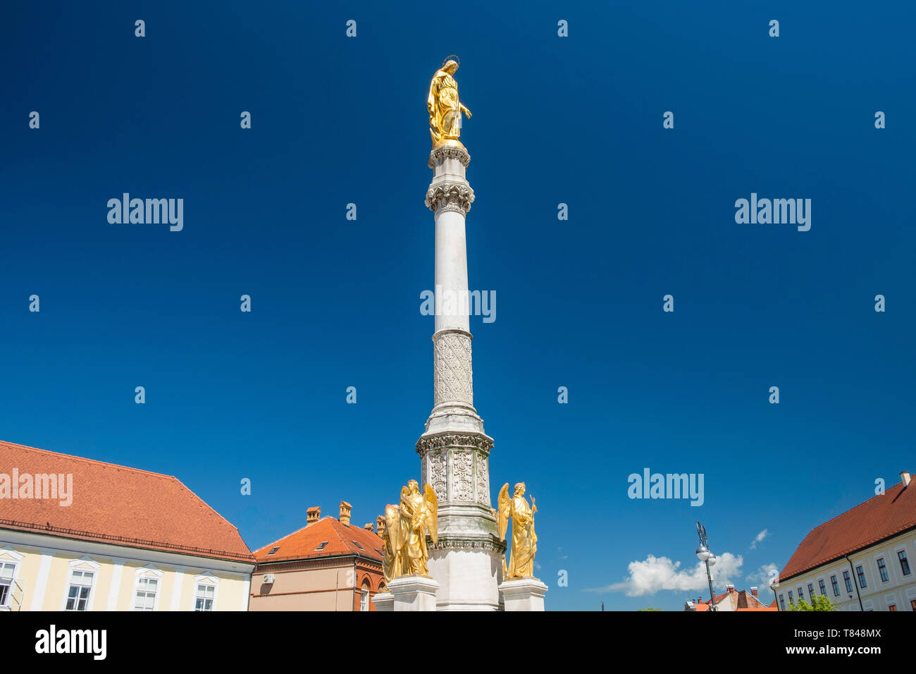 Maria colonna con golden statue degli angeli di fronte cattedrale di Zagabria, Croazia, cielo blu Foto Stock