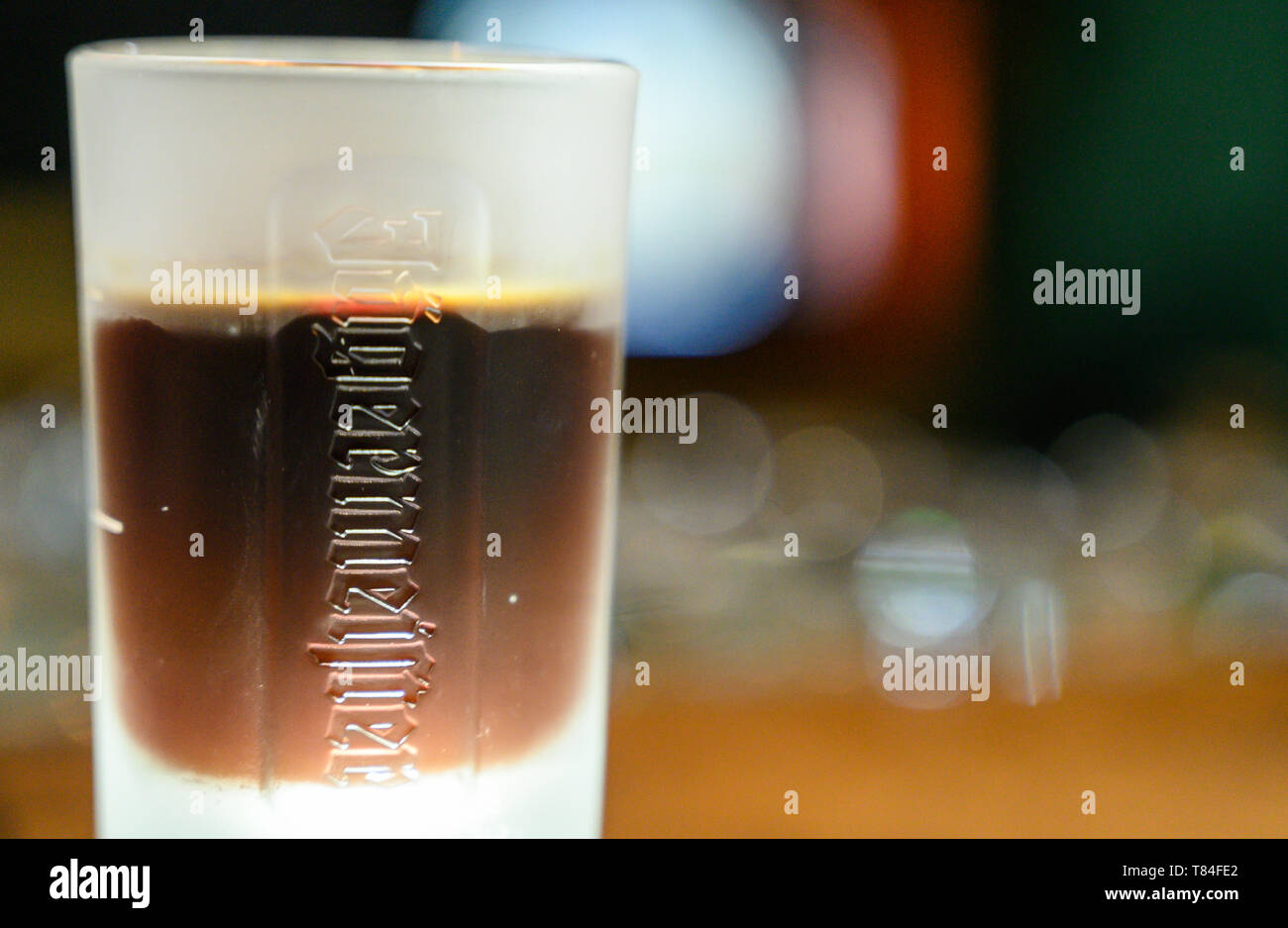 10 maggio 2019, Bassa Sassonia, Wolfenbüttel: All'apertura del nuovo impianto di imbottigliamento di bevande Jägermeister produttore, con un bicchiere di grappa alla Jägermeister sorge su una barra. Con questa espansione, Jägermeister ha, secondo le proprie informazioni, realizzato uno dei più grandi spiriti di impianti di imbottigliamento in Europa. Foto: Christophe Gateau/dpa Foto Stock