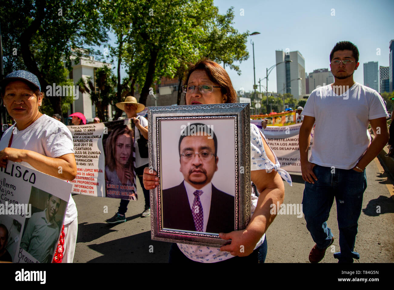 Città del Messico. Il 10 maggio, 2019. Una donna che porta le foto di lei marito mancante in una protesta da parte di che numerose donne chiesto una spiegazione della sorte dei loro bambini rapiti e parenti. In Messico, circa 40.000 persone sono considerati mancanti. Molte persone sono state uccise. Essi sono spesso vittime di potenti cartelli della droga e la grande criminalità. Credito: Jair Cabrera Torres/dpa/Alamy Live News Foto Stock