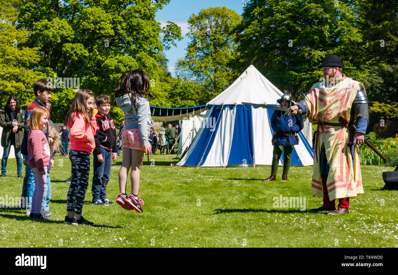 Dirleton Castle, East Lothian, Scozia, Regno Unito, 11 maggio 2019. Giornata medievale: ambiente storico la Scozia e per il divertimento di tutta la famiglia giorno alla vita del villaggio medievale nei giardini del castello. Bambini divertirsi imparando a marzo in un esercito Foto Stock