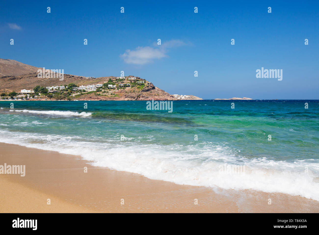 Panormos, Mykonos, Egeo Meridionale, Grecia. Vista dalla spiaggia sabbiosa attraverso le acque turchesi di Panormos Bay. Foto Stock