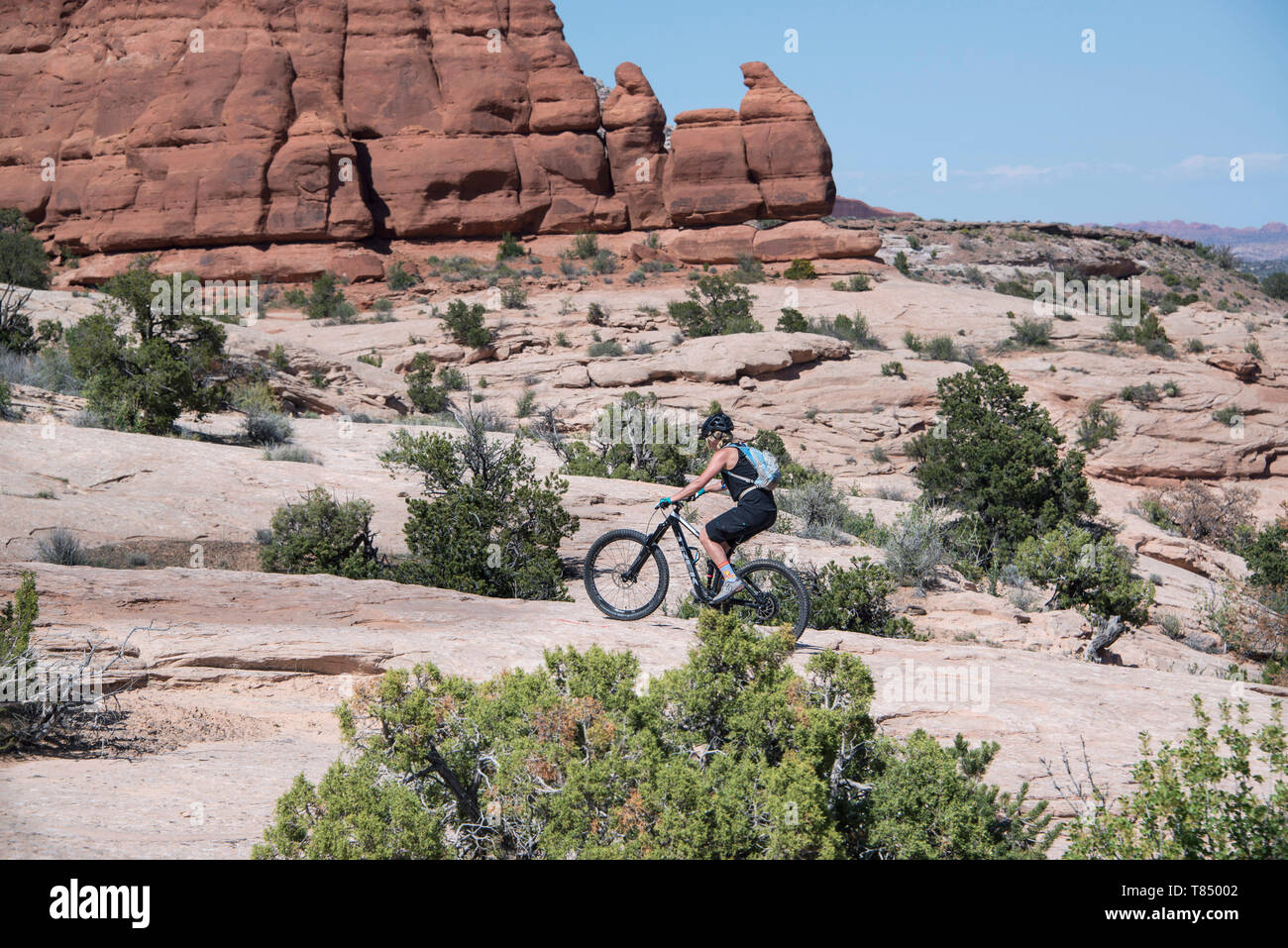 Mountain biker donna femminile in sella alla sua bici fat pneumatico su Slickrock nella scenografica Moab, Utah, Stati Uniti, maggio 03rd, 2019 Foto Stock