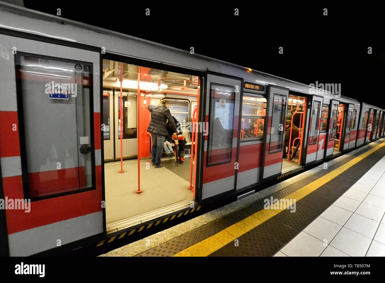 Un tubo con il treno alla stazione con sportello aperto. N. persone sulla piattaforma. Alcuni viaggiatori seduti in treno. Foto Stock