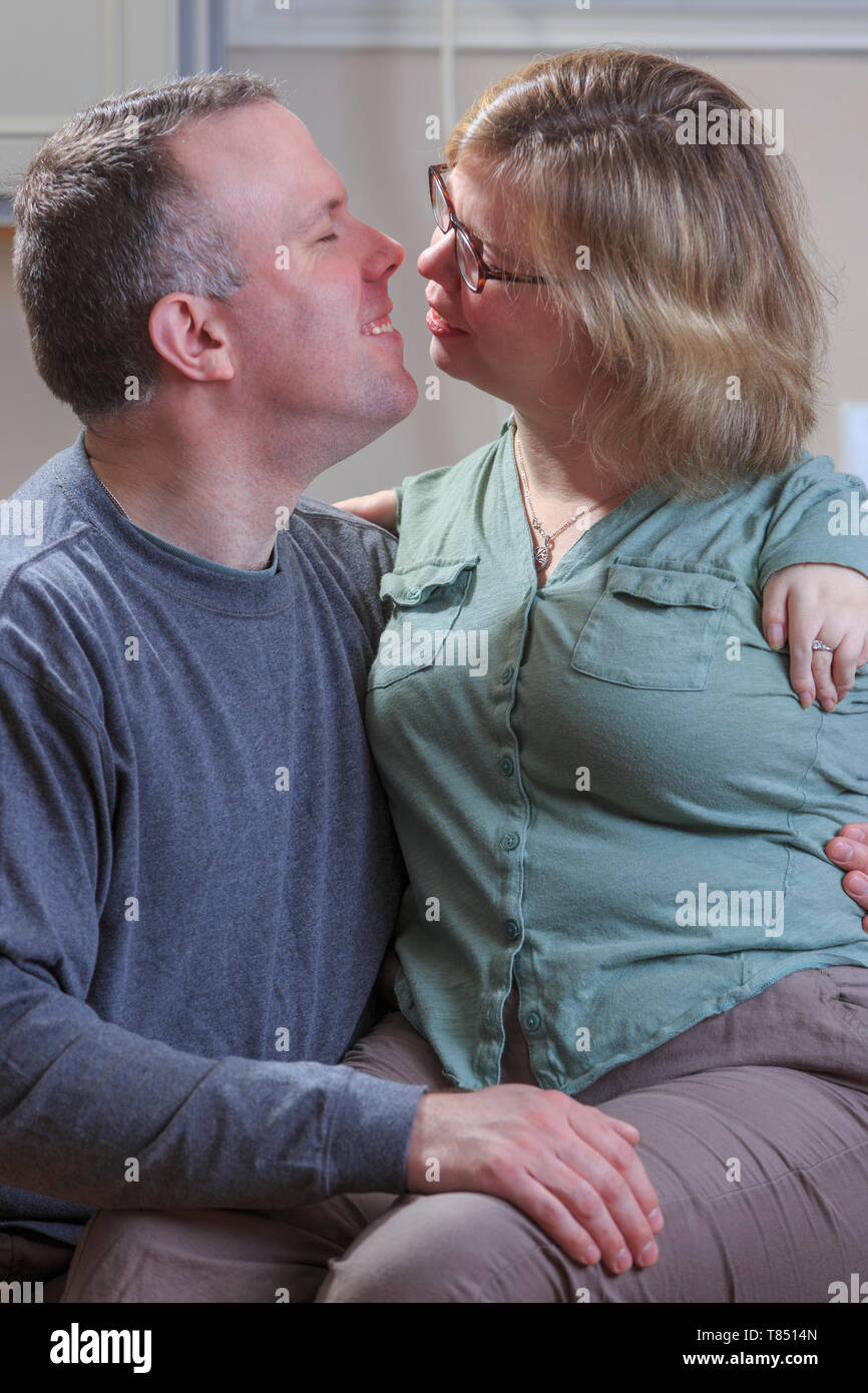 Donna con sindrome di catrame circa a baciare il marito Foto Stock