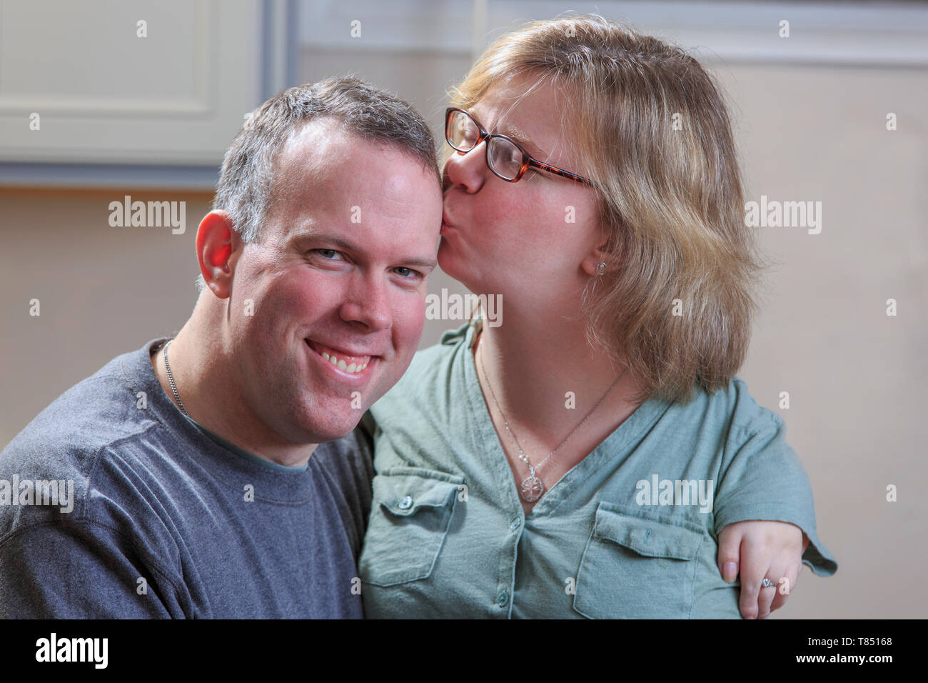 Donna con sindrome di catrame baciare il marito Foto Stock