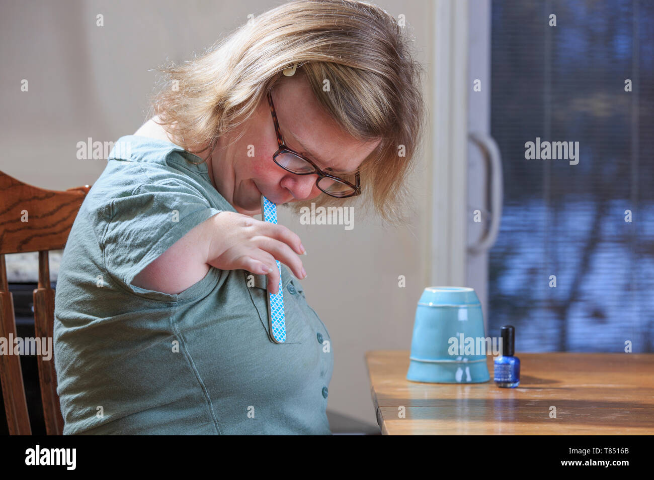 Donna con sindrome di catrame deposito i suoi chiodi a casa Foto Stock