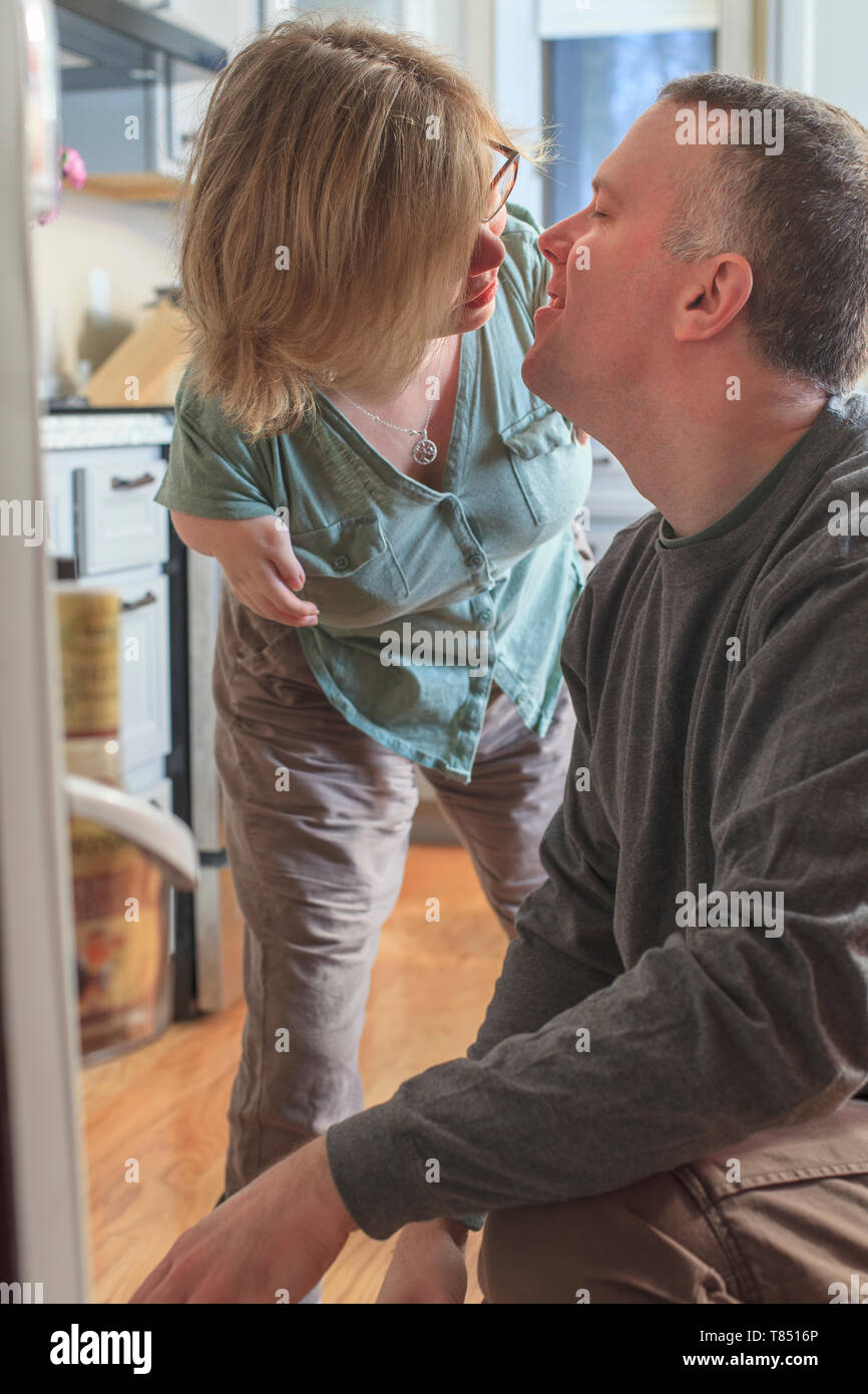 Donna con sindrome di catrame e suo marito baciare a casa Foto Stock