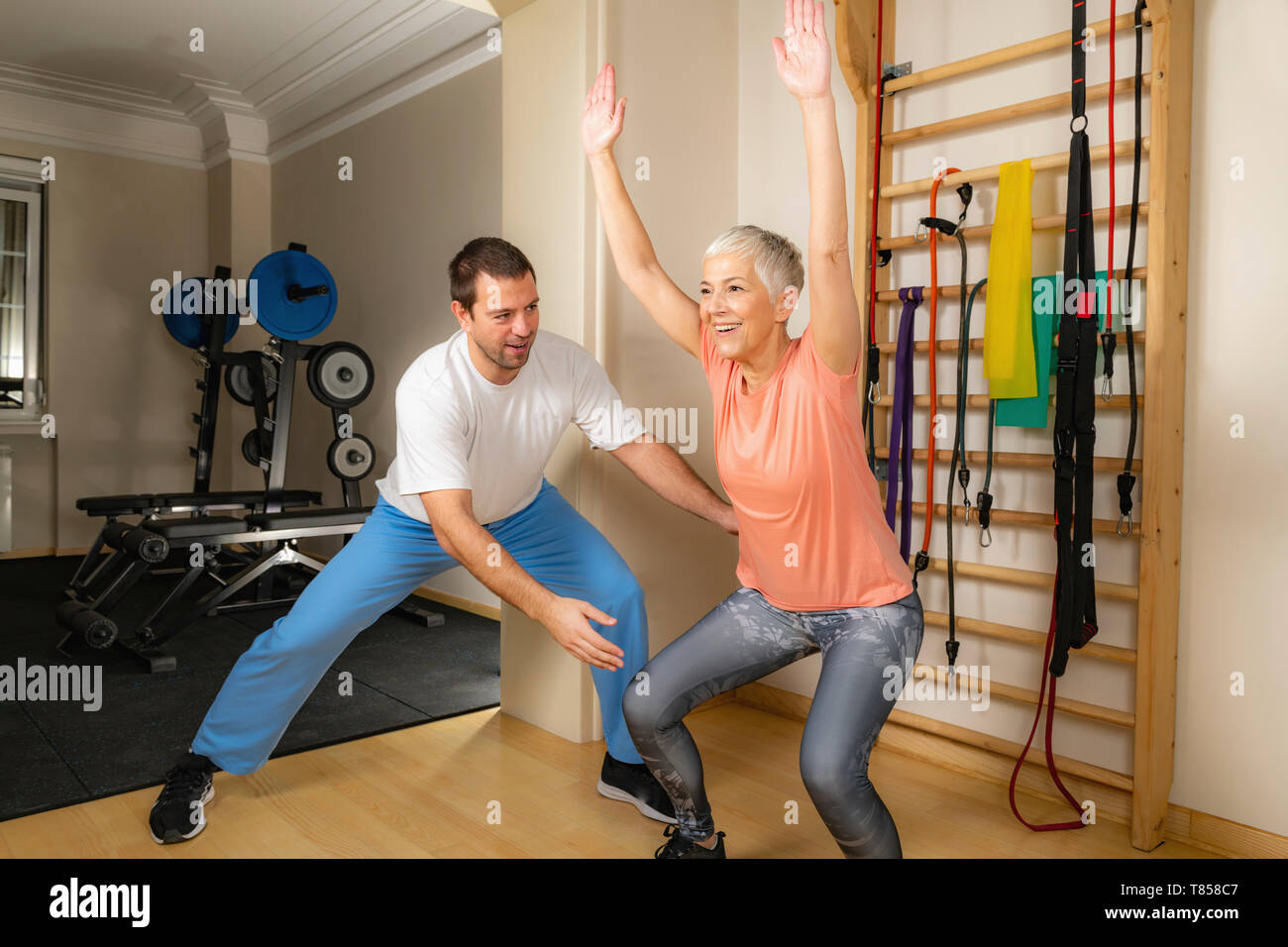 Senior donna facendo squat Foto Stock