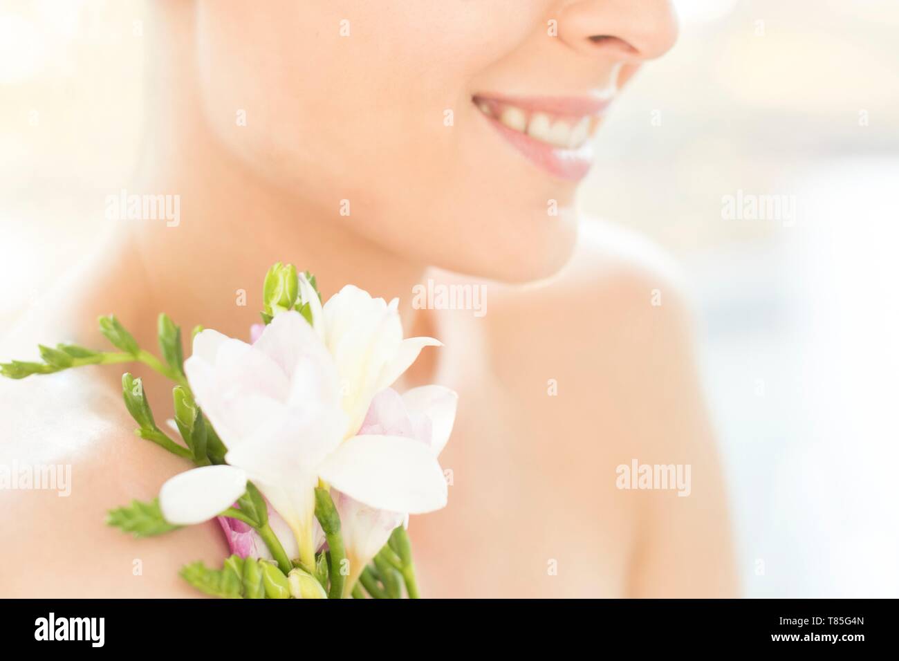 Donna sorridente holding fiori Foto Stock