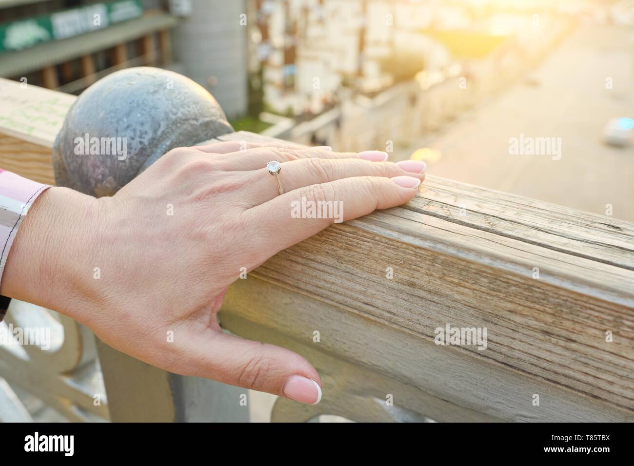 Primo piano della mano 40 maturo, donna di 45 anni, chiodi con manicure, l'anello sul dito, all'aperto. Foto Stock