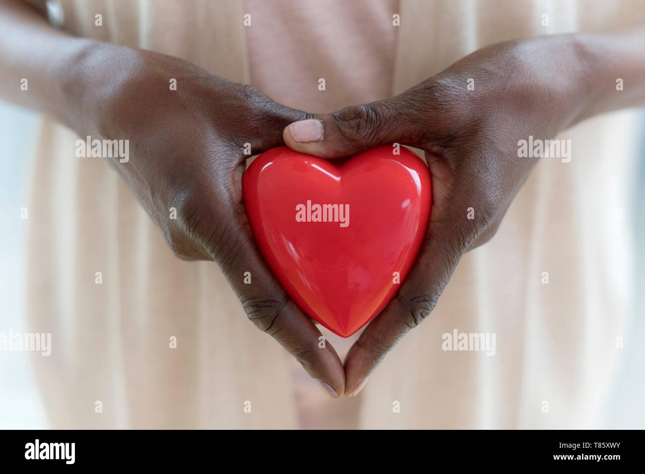 Donna che mantiene la forma di cuore Foto Stock