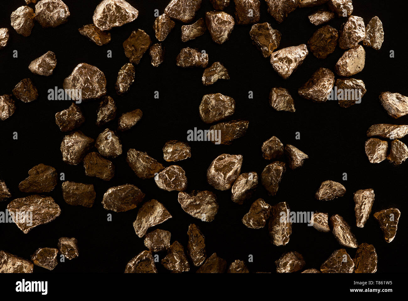 Vista superiore della diffusa pietre oro isolato su nero Foto Stock