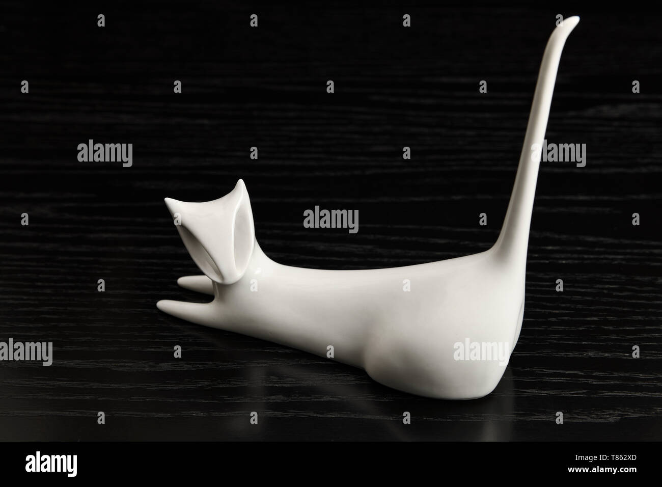 Porcellana Bianca gatto con il tail rialzato su un Rovere nero tabella Foto Stock