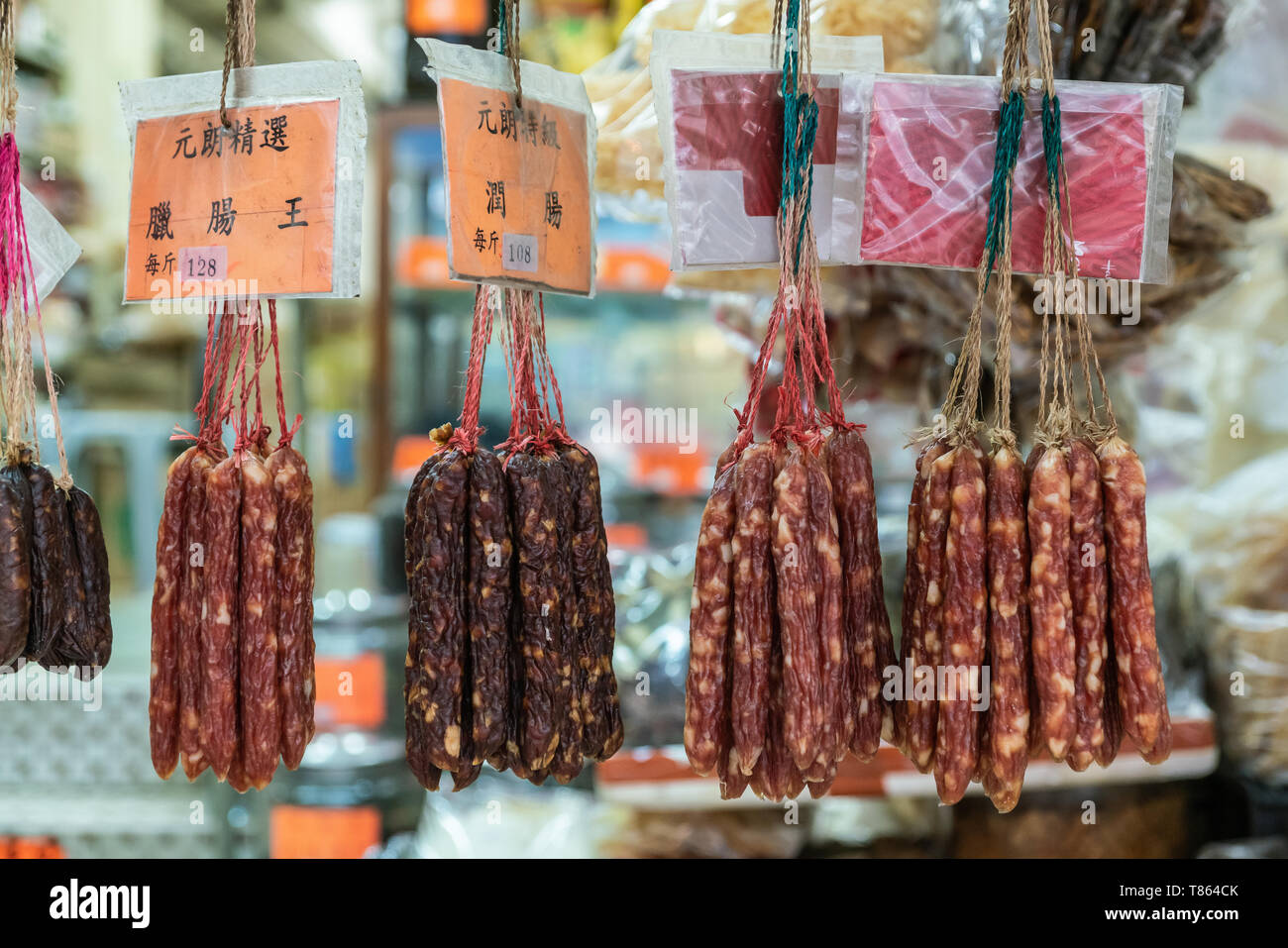 Hong Kong, Cina - 8 Marzo 2019: Mercato Tai Po in un nuovo territorio. Primo piano della selezione di salsiccia secca si blocca nella finestra aperta del negozio. Foto Stock