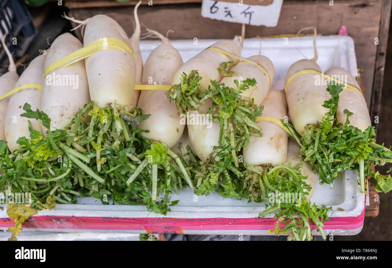 Hong Kong, Cina - 8 Marzo 2019: Mercato Tai Po in un nuovo territorio. Vista dettagliata del mazzetto di cinesi il radicchio bianco verdure, o Daikon. Foto Stock
