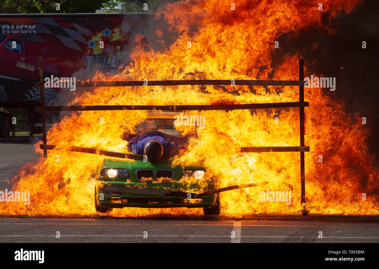 Francia, Hauts de Seine, Puteaux, stunt show, stuntman sul cofano di una vettura di attraversamento di una barriera di fuoco Foto Stock
