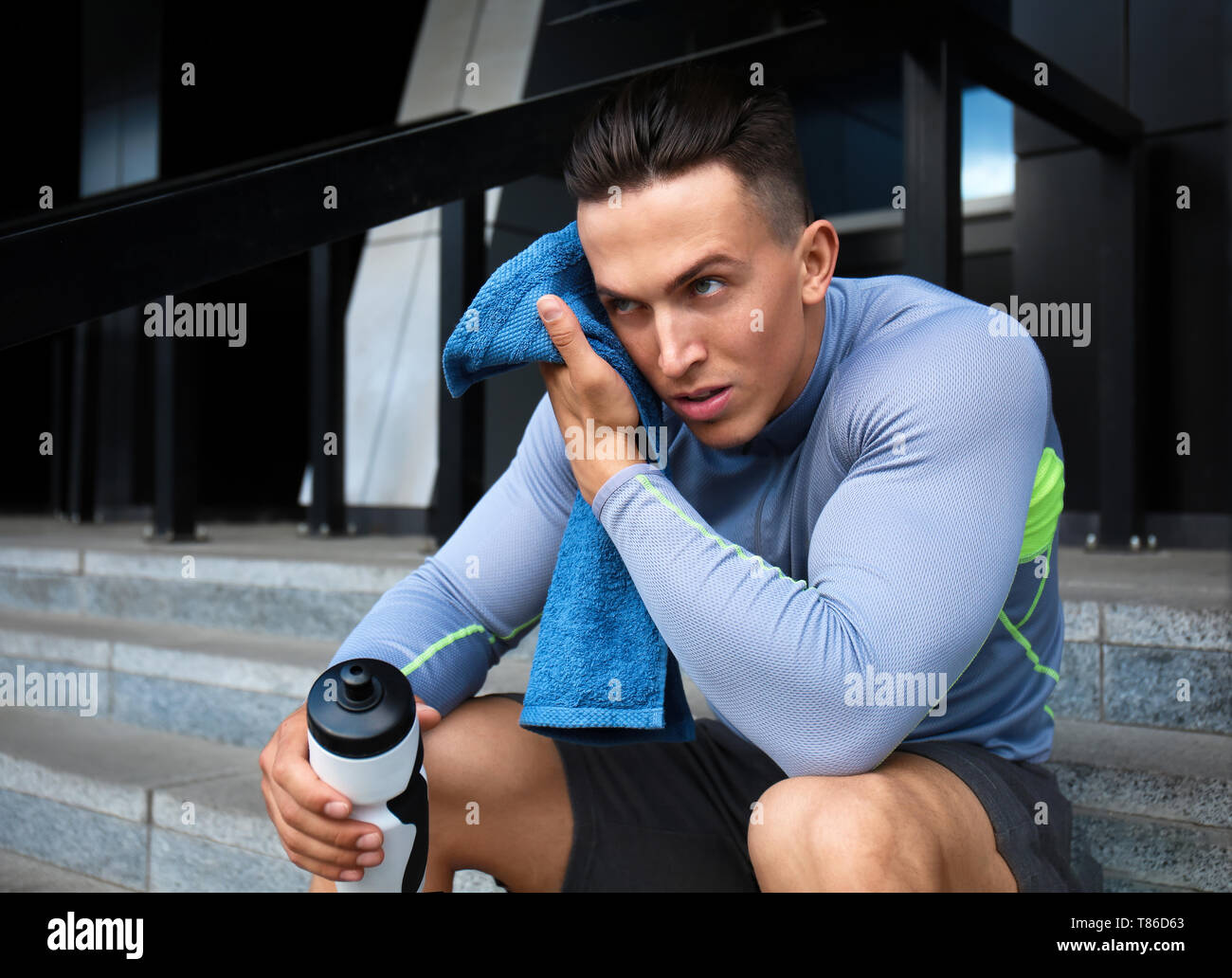 Sporty giovane di riposo dopo la formazione all'aperto Foto Stock