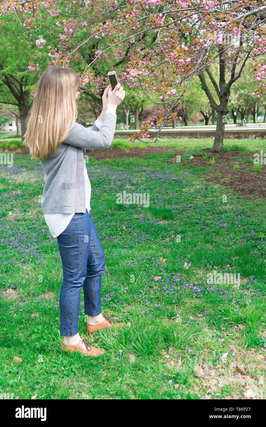 Attraente donna millenaria nel parco, vivere e godere la vita, guardando come uno stile di vita ad Foto Stock