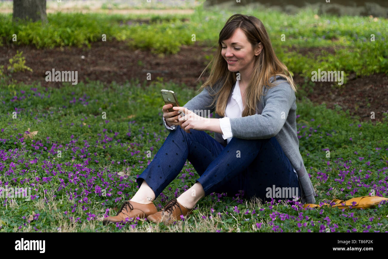 Attraente donna millenaria nel parco, vivere e godere la vita, guardando come uno stile di vita ad Foto Stock