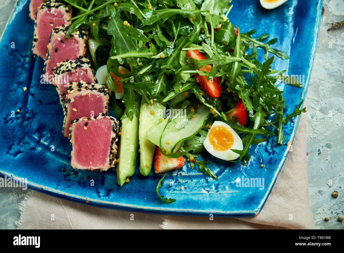 Tonno con insalata e verdure su un bel piatto di colore blu e grigio Foto Stock