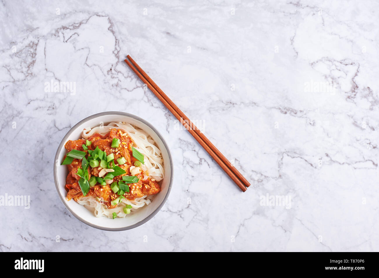 Shan tagliatelle con bacchette in marmo bianco del piano portapaziente. cucina birmana piatto tradizionale. myanmar cibo. spaghetti di riso con carne di maiale in pomodori. piatto asiatico Foto Stock